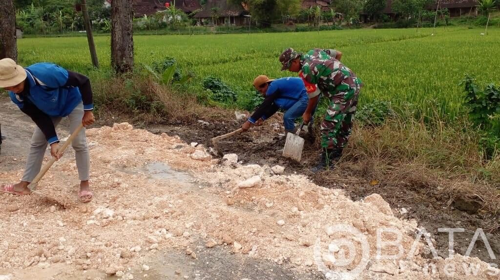 Tutup Jalan Berlubang, Babinsa Bersama Masyarakat Karya Bakti