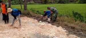 Tutup Jalan Berlubang, Babinsa Bersama Masyarakat Karya Bakti