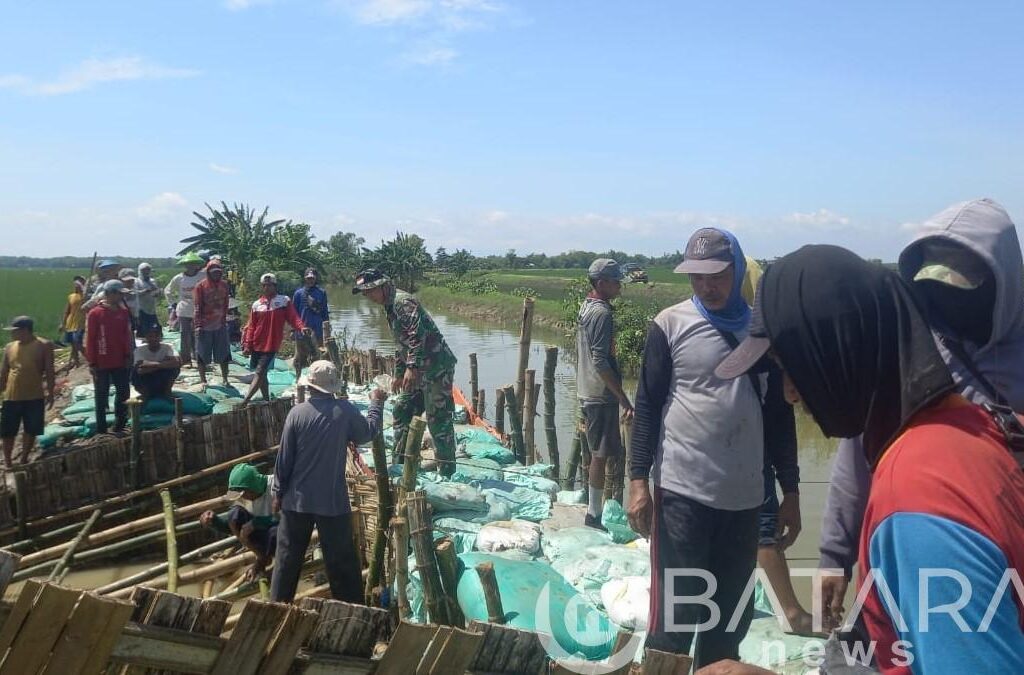 Karya Bakti Lanjutan, Babinsa Koramil Kanor Bojonegoro bantu Penutupan Tanggul Jebol di Kedungprimpen